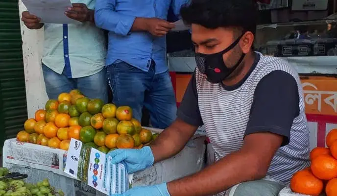 A Bangladesh trader reads COVID-19 messaging