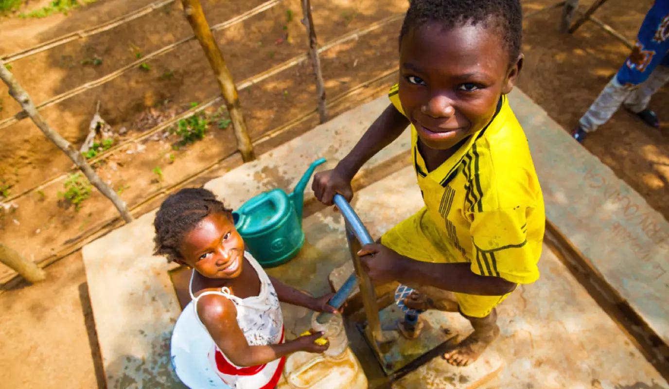 Two children pump water