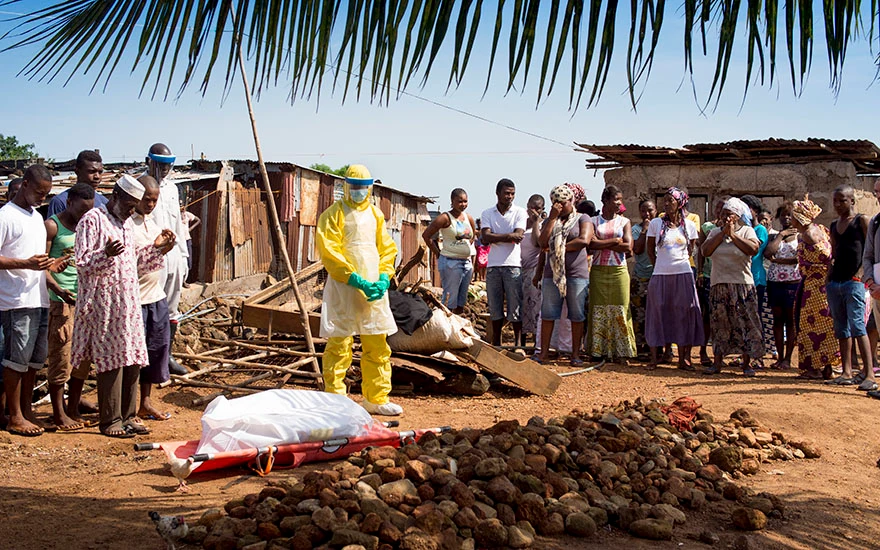 Family and friends pray over a dead body.