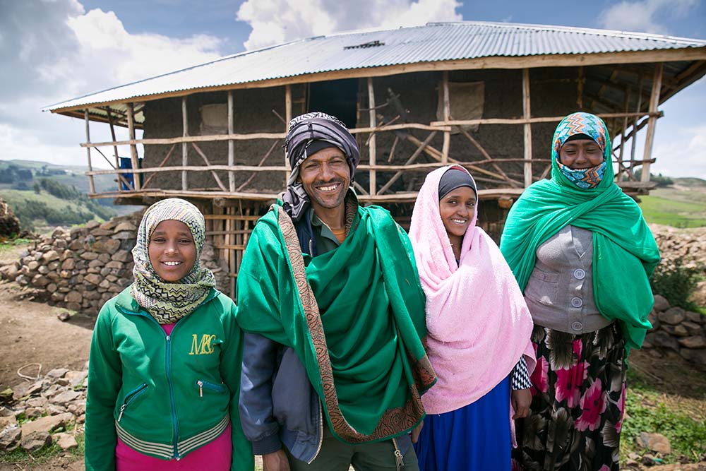 Ali and his family in front of their new home.