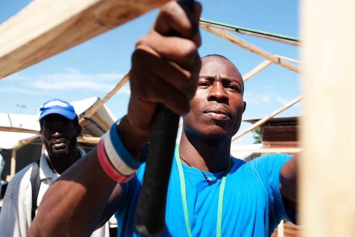 Two people building a house.