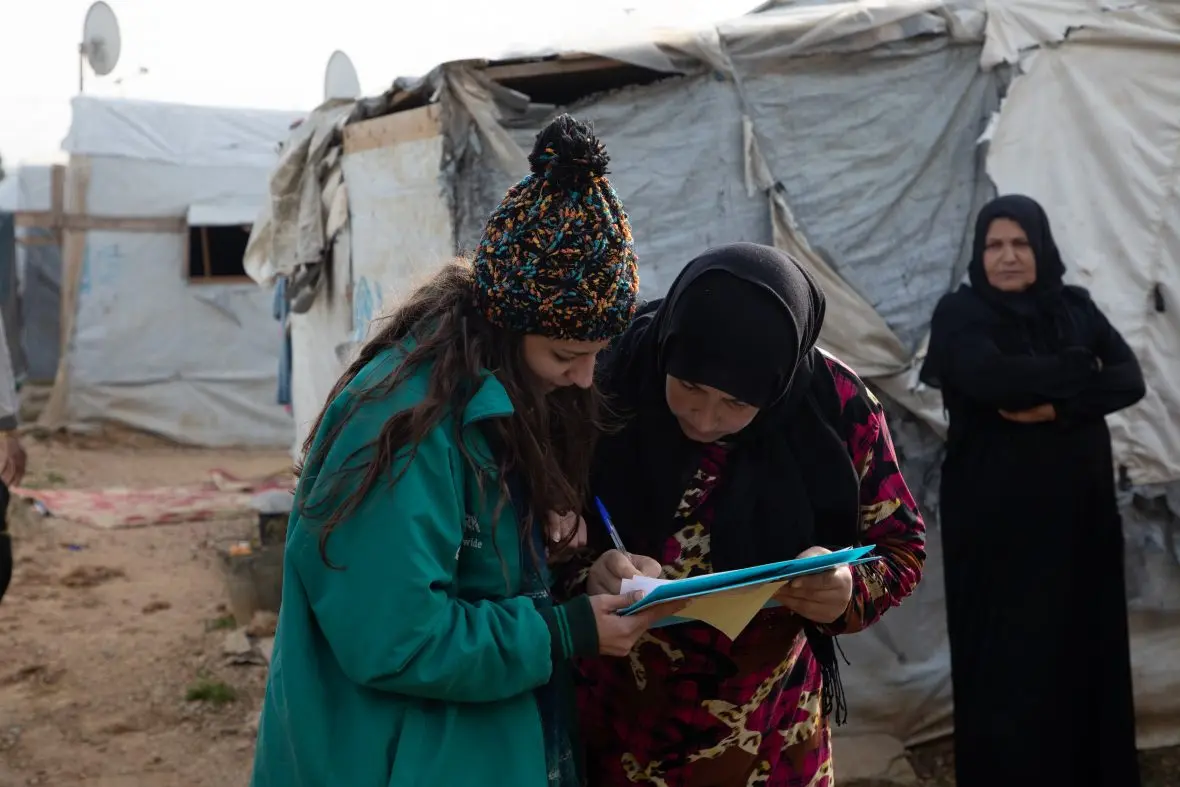 A Syrian refugee in Lebanon signs for supplies