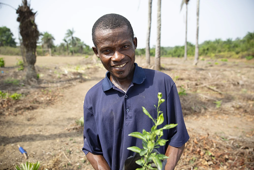 A Liberia man with a fruit tree sapling