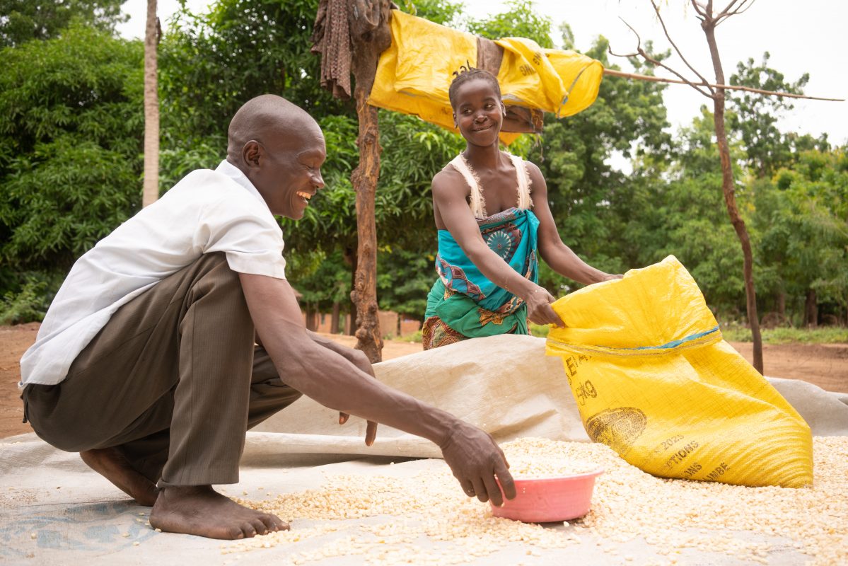 Since partaking in the Umodzi gender equality program in Malawi, Forty Sakha helps his wife Chrissy with household chores like drying maize. (Photo: Chris Gagnon / Concern Worldwide)