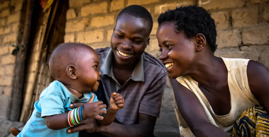 A Congolese couple play with their 7-month-old baby Bienheureux in the village of Pension, Manono Territory, where they have been internally displaced due to conflict