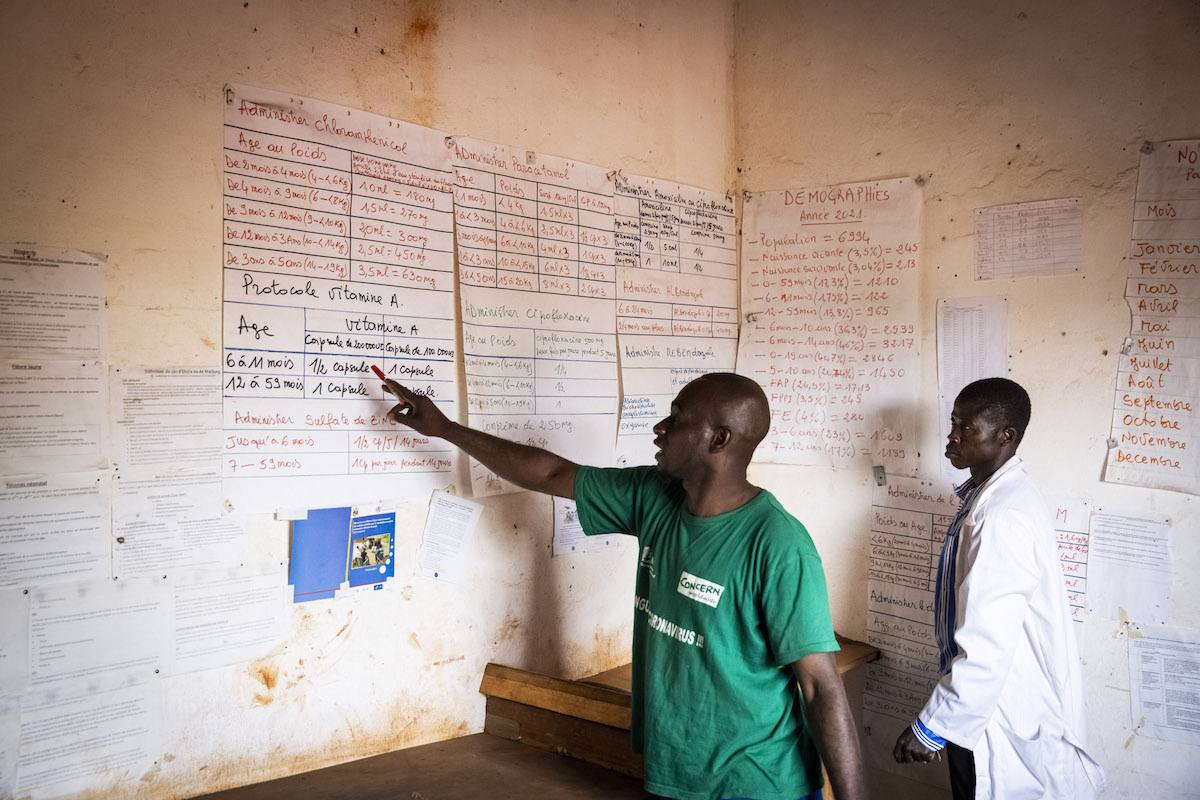 Emmanuel*, Community Health Worker (CHW) in Boyali and Corneille Frizoui, in charge of stock, in the store room a the health centre in Boyali. (Photo: Ed Ram/Concern Worldwide)