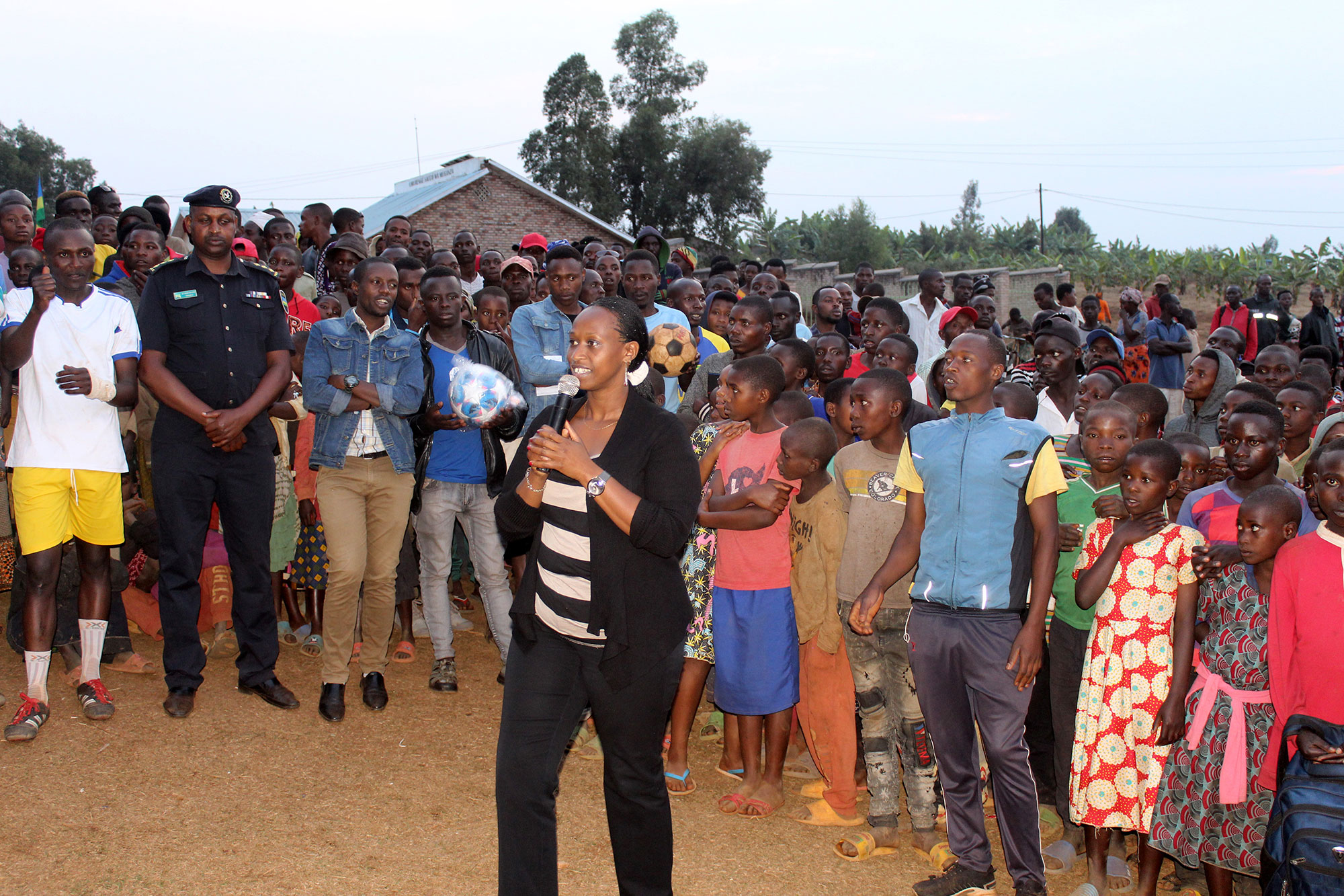 Denise Dusabe, Vice Mayor of Social Affairs in Gisagara district, presents at an HIV/AIDS prevention and family planning event organized by Concern Rwanda. Five local teams participated in a soccer championship, with government representatives presenting both speeches and prizes. Local health center staff also offered voluntary HIV testing, distributed free condoms, and helped couples with selecting appropriate family planning methods.