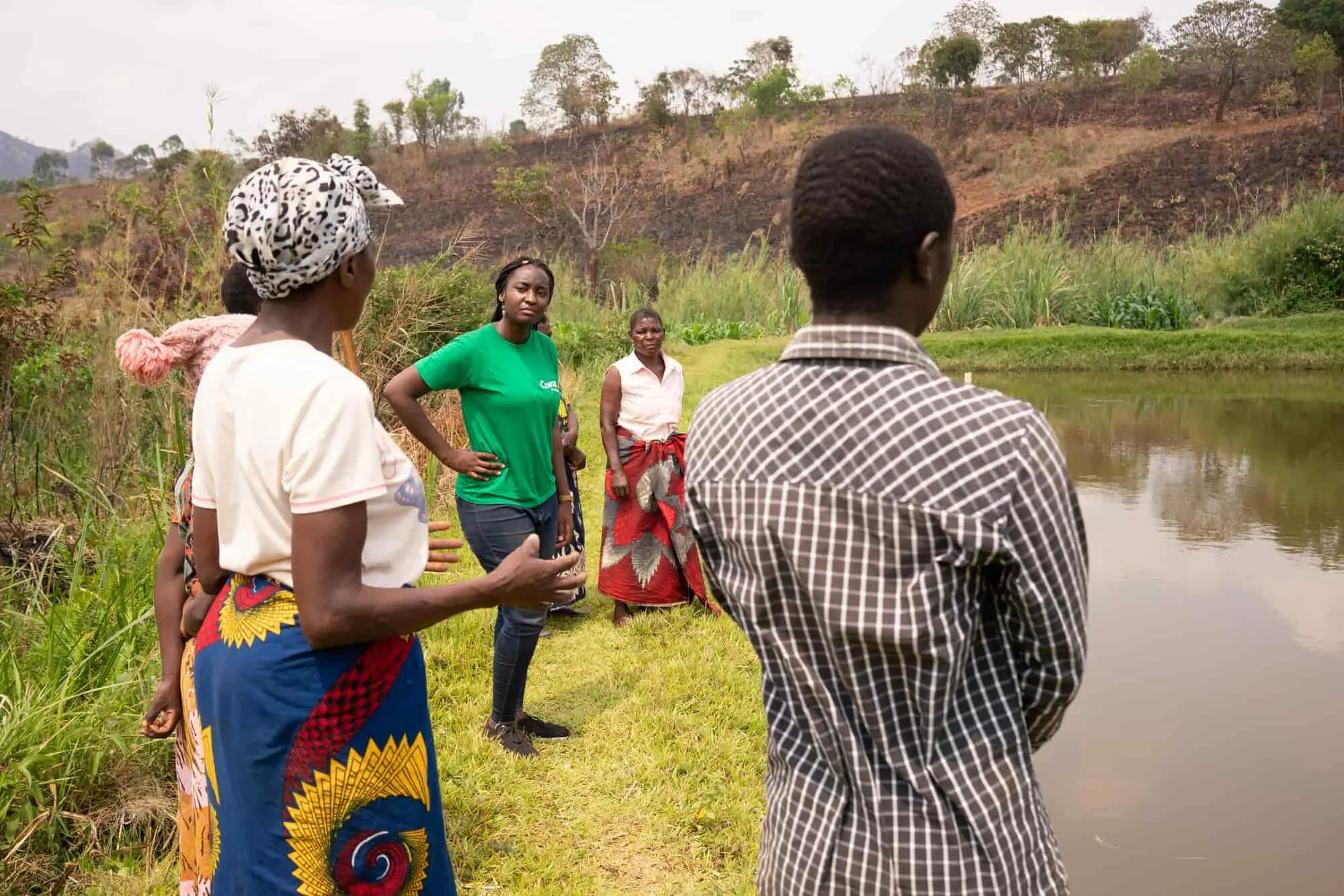 Concern worker talking with farmers in field