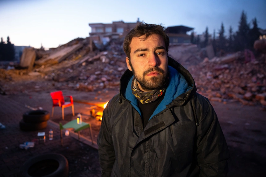 Survivor of 2023 earthquake in front of ruined building