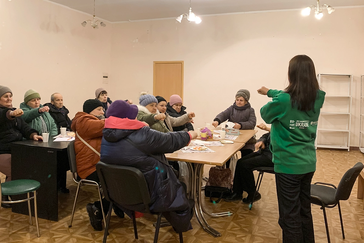 Lilia (right, in the green sweatshirt) leads a psychosocial support session for senior citizens in Zaporizhzhia. The group meets weekly for group counseling and includes internally-displaced Ukrainians as well as locals. (Photo: Olivia Giovetti/Concern Worldwide)