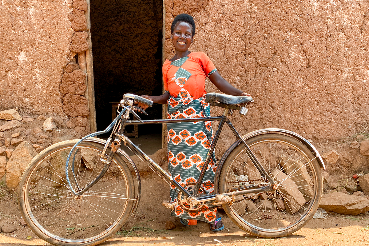 Concern Rwanda Gradutation program participant Marie-Claire Ayinkamiye shows off her bicycle, which she bought with the profits from her business selling grains and legumes. (Photo: Eugene Ikua/Concern Worldwide)