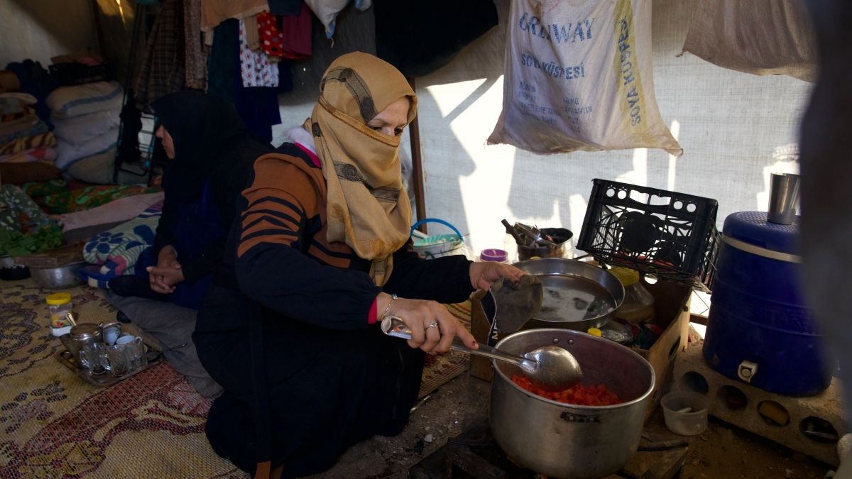 Reem* (30) prepares food for her husband Jaafar* (32) and her children inside their tent in the Ahl al-Khair camp, Syria. (Photo: Concern Worldwide)