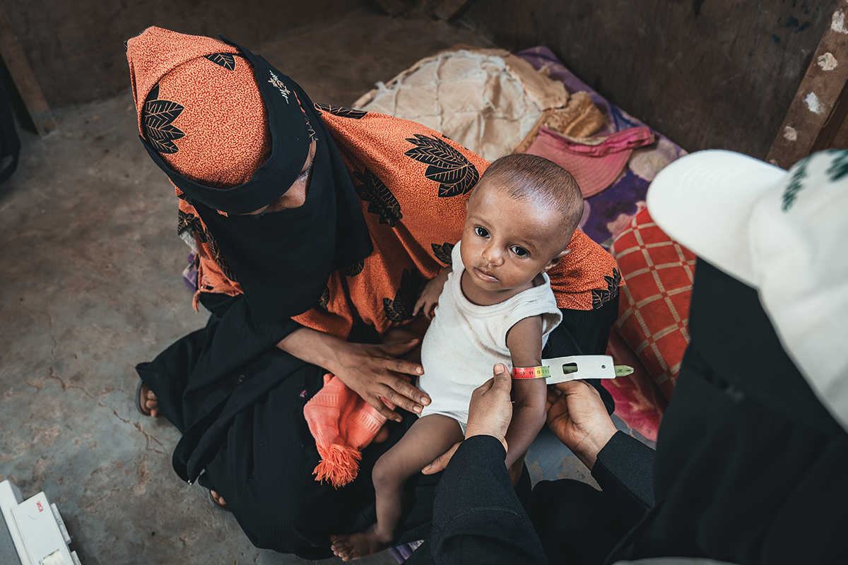 A Community Health Volunteer visits a shelter in Auteera IDP site in Tuban district. Mother Amina* and baby Sabi* receive a follow-up visit to check the Sabi's nutritional status. (Photo: Ammar Khalaf/Concern Worldwide)