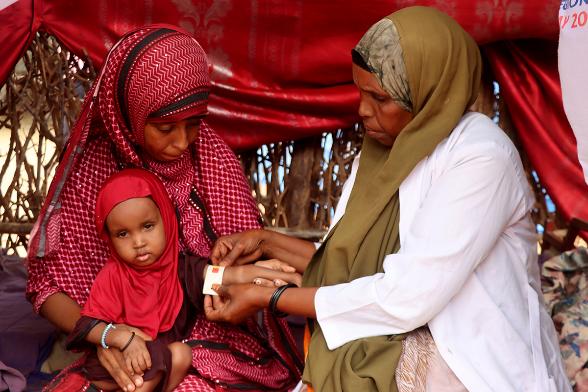 Mother-to-mother support groups play a vital role in enhancing breastfeeding practices and reducing child wasting. At this session in Dollo, Ethiopia, Nurto Mohamud Mohamed learns to monitor her daughter, Anfa's, nutrition with MUAC tape. (Photo: Adan Mohamed Afar/Concern Worldwide)