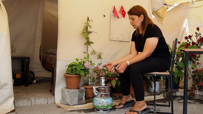 Turkish woman making coffee outside her temporary tent home