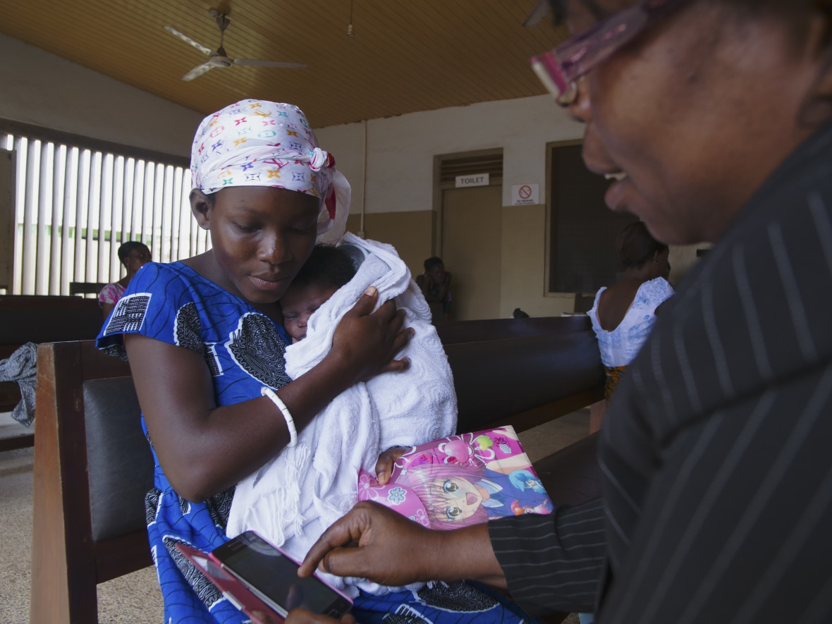 A nurse and new mother look at the CHN on the Go app together at a clinic.