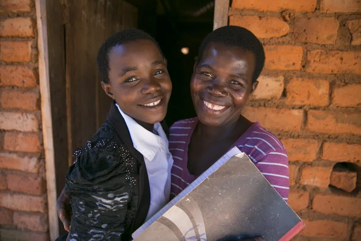 Stawa James with her daughter, Laisa James, outside their new home in Mangochi, Malawi.