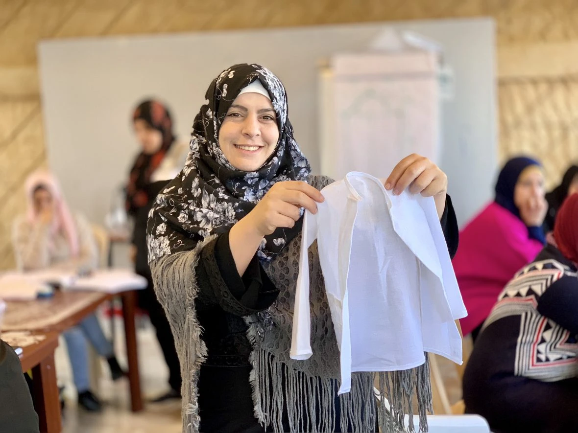 A woman holding a small shirt.