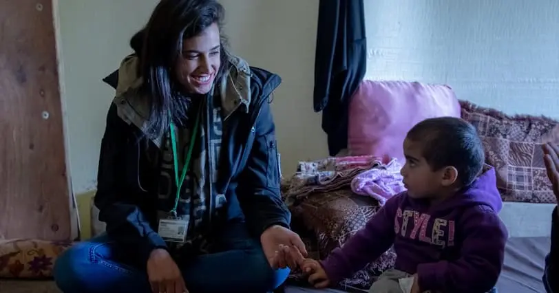 Concern Staff member, Aisha plays with young child.