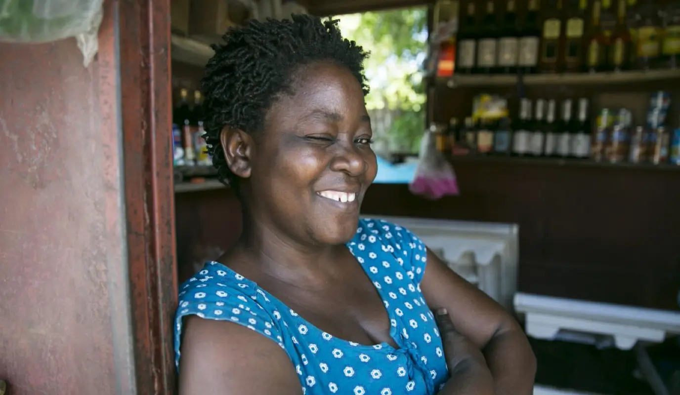 Woman standing at her shop entrance smiling