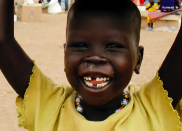 A child with food, supplies, and water from Concern Worldwide and other humanitarian organizations in Tomping, a UN base.