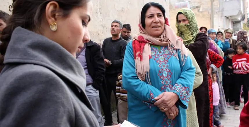 Families queue as food and other aid items for Syrian refugees are distributed